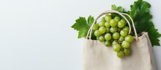 Fototapete - Eco friendly beige shopping bag featuring grapes on a white background String bag containing fruits Zero waste plastic free concept Copy space