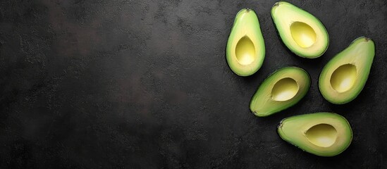 Aufkleber - Freshly sliced avocado on a black textured background top view. with copy space image. Place for adding text or design