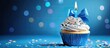 © vxnaghiyev - Happy birthday cupcake with a bow candle on a blue background featuring copy space Adorable food inspired happy birthday backdrop idea