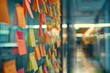 © NikoG - Post it notes on the wall with it team meeting in background