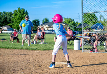 Youth girl softball player at bat during a game.