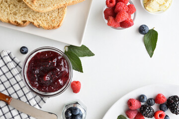 Wall Mural - Breakfast with wild berry jam on white table top view.