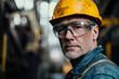 © Peter - Middle-aged worker in safety glasses and a yellow helmet at a steel plant, standing in front of a blurred industrial background. Emphasizes safety, professionalism, and industrial work.