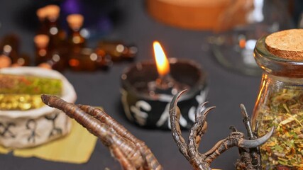 Wall Mural - Witchcraft still life focus shift with black burning candle in the cup with magic symbols. Esoteric gothic and occult witch craft for Halloween. Various magic objects and ritual arrangement.