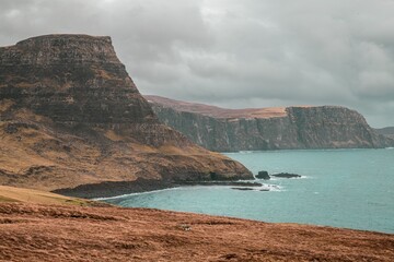 Wall Mural - View of dramatic cliffs and coastline on a cloudy day in the Isle of Skye, Scotland