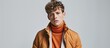 © vxnaghiyev - Full length portrait of a tall attractive man wearing an orange turtleneck grey jacket and white jeans posing against a green background. with copy space image. Place for adding text or design
