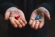 © Livinskiy - Outstretched hands holding a red pill and a blue pill, representing a choice between two alternatives