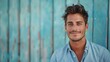 © olegganko - Young Man Smiling Against a Blue Wooden Wall in Daylight