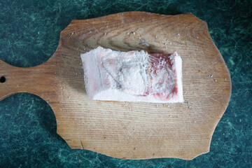 Pork on a wooden board, natural fat.