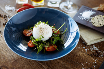 Wall Mural - Burrata with paprika-truffle jam and cherry-cluster tomato salad. Delicious healthy Italian traditional food closeup served for lunch in modern gourmet cuisine restaurant