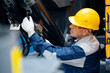 © Parilov - Concept industry truck maintenance. Machinery tractor mechanic checks hydraulic hose system equipment on excavator