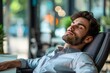 © Yuliia - Beautiful young businessman relaxing in a chair behind his desk at the office, enjoying the fresh open air.