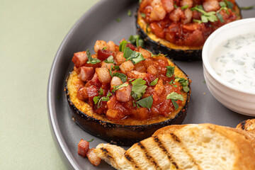 Wall Mural - Eggplant appetizer with tomatoes and toast on green background