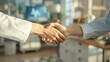 © LuvTK - A professional photo of a handshake between a patient and a doctor in a contemporary clinic, captured from a slightly elevated angle.