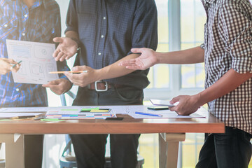 Wall Mural - smooth focus, group of web designers are working together to develop mobile responsive website with 