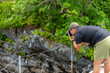 © SandraSevJarocka - male hiker photographing the beauty of the fjord in andalsnes isfjorden area on a cloudy summer day in the woods close to massvassbu