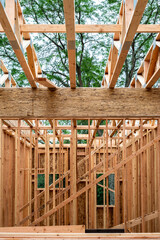 Wall Mural - Interior new house construction at wood framing stage, looking up at main Parallel Strand Lumber, PSL, support beam and prefabricated truss beams of second floor
