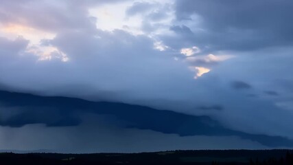 Sticker - A timelapse sequence of dark brooding clouds inching their way across the sky obscuring the sun in their wake.