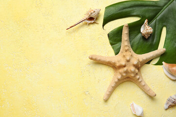 Wall Mural - Composition with palm leaf, starfish and seashells on yellow background