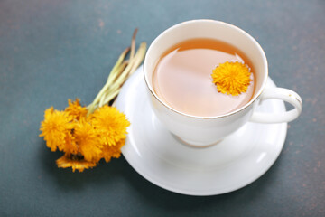 Wall Mural - Cup of healthy dandelion tea on dark background