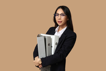 Sticker - Portrait of young Asian businesswoman with office folders on beige background