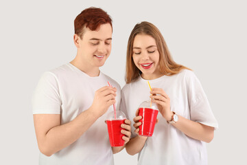 Canvas Print - Happy young couple drinking cola on white background