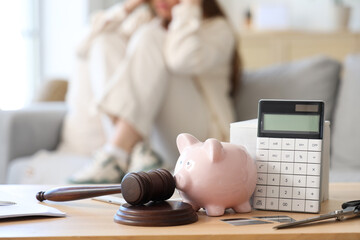 Sticker - Piggy bank with judge's gavel and calculator on table of bankrupt woman at home, closeup