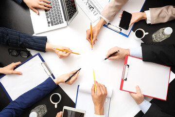 Business people working at black table, top view