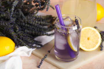 Wall Mural - Glass of fresh lavender lemonade with flowers and lemons on beige table