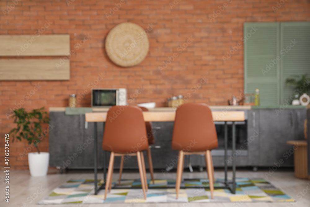 Blurred view of kitchen with black counters and dining table