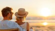 A couple relaxes on the beach during sunset, sitting close together and enjoying the serene view of the ocean and the impressive orange sky reflecting on water, creating a romantic atmosphere.
