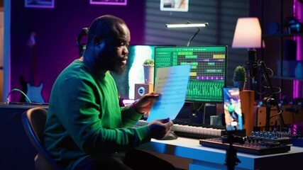 Leinwandbilder - Artist pointing at musical sheet notation to explain notes on piano, teaching people to play synthesizer in home studio. Composer musician playing midi controller during online master class. Camera A.
