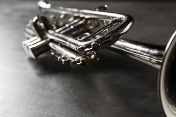 Wall Mural - Closeup view of shiny trumpet on grey textured table. Wind musical instrument