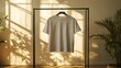 © IttikornP - White t-shirt mockup shown on a simple rack against a plain, bright wall, highlighting the clean lines
