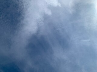 Wall Mural - an image of a sky with thinly scattered white clouds and bright light.