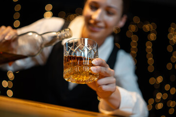 Wall Mural - Barwoman pouring whiskey whiskey glass..