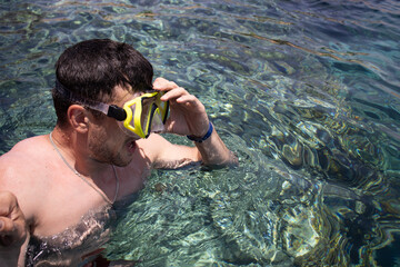 European man snorkeling in the sea. Brunette guy with mask and snorkel for swimming. Diving on vacation