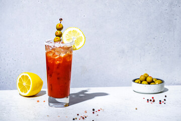 Wall Mural - Tomato  alcoholic cocktail drink, variation of Bloody Mary with juice, vodka, lemon, celery, spicy sauce and ice. Gray background, hard light