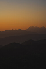 Wall Mural - nature traveling with orange sky and layer of mountain with sunrise background