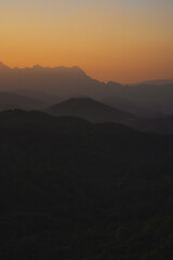 Wall Mural - nature traveling with orange sky and layer of mountain with sunrise background