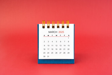 Wall Mural - March 2025 white desk calendar on red background.