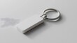 © Prime Stox - White keychain mockup on a light grey surface with soft shadows, focusing on its sleek design