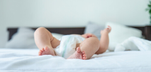 A newborn baby lies on a white background with a soft toy bunny. baby