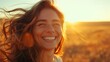 © ifoto - A beautiful woman laughing and smiling with her hair blowing in the wind on an open field at sunset.