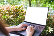 © Farknot Architect - Mockup image of a woman using and typing on laptop computer with blank white desktop screen in the outdoors