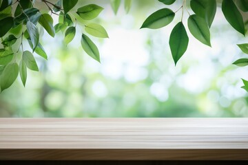 Canvas Print - Green leaves and wooden table with blurred background