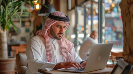 Arab man using laptop in cafe