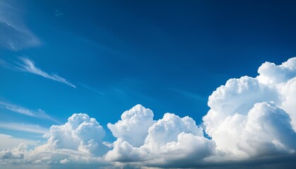 Wall Mural - a beautiful cloudscape with large white clouds in a clear blue sky perfect for banners cards or serene outdoor backdrops