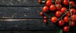 © StockKing - Fresh, red tomatoes arranged on a vintage black wooden table with copy space image.
