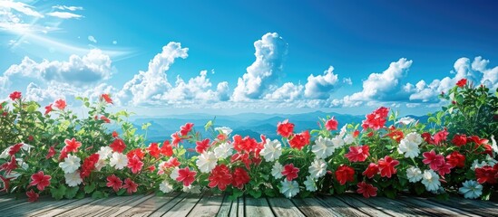 Poster - A scenic image featuring red and white mandevilla flowers on a deck set against a lush green forest under a beautiful blue sky with a few white clouds Copy space included